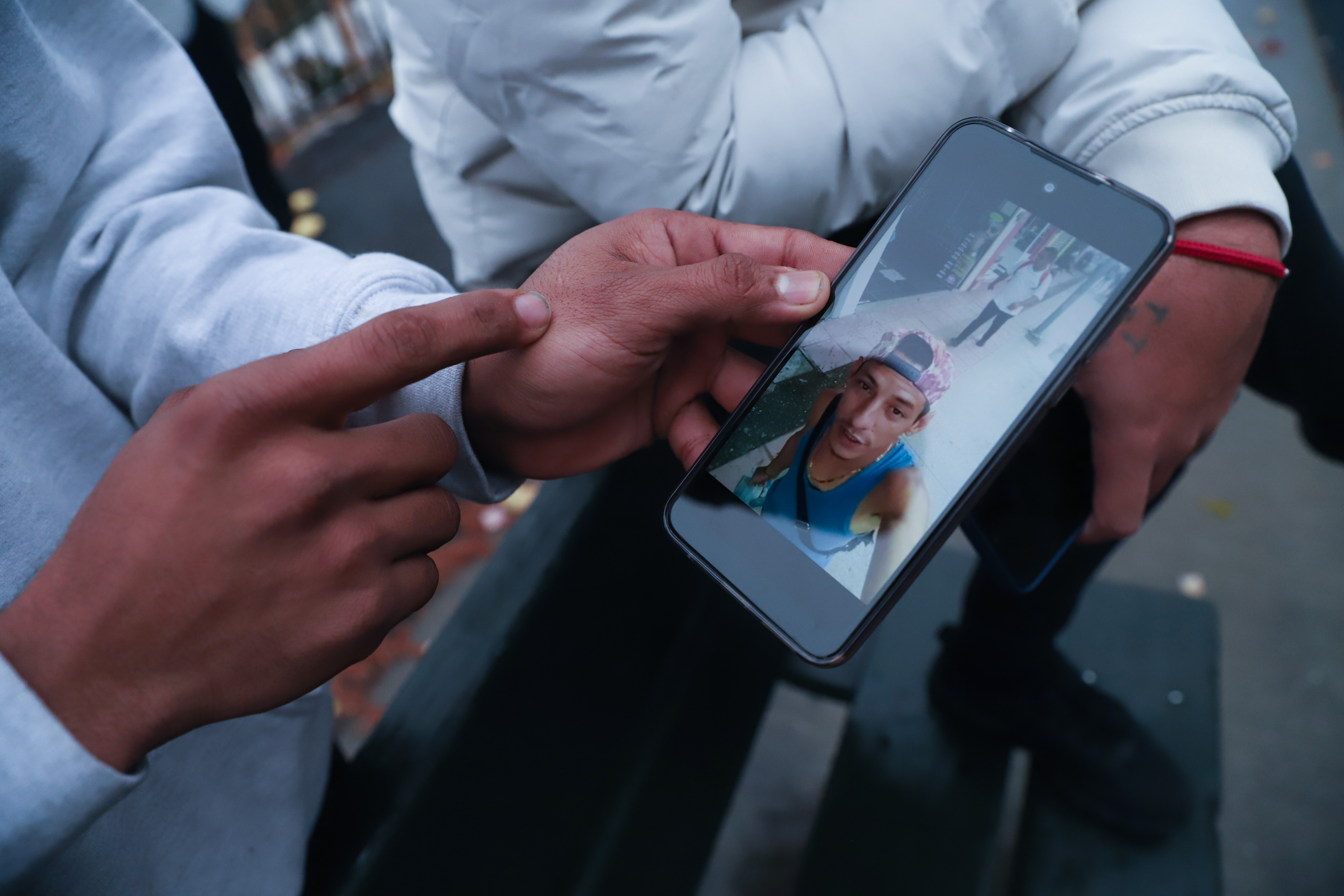 A close-up photo of a mobile phone showing a picture of a young man's face