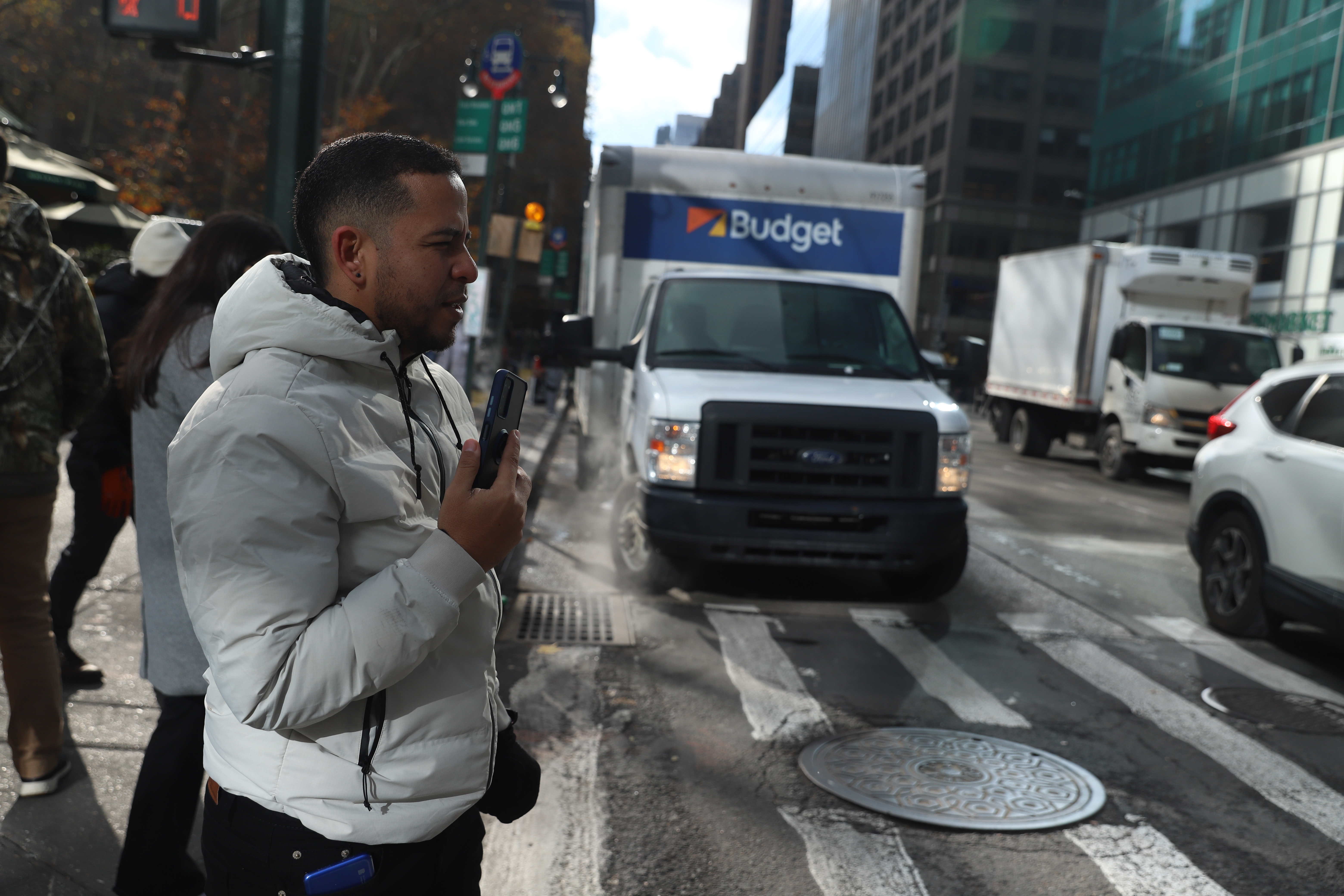 Tonny Tavera stands at a crossroads in New York City and speaks into his phone.